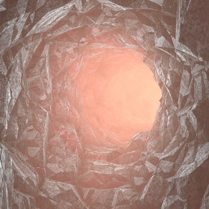 Apertura en una superficie rocosa con tonos suaves de rosa y gris. Soporte oncológico coadyuvante.