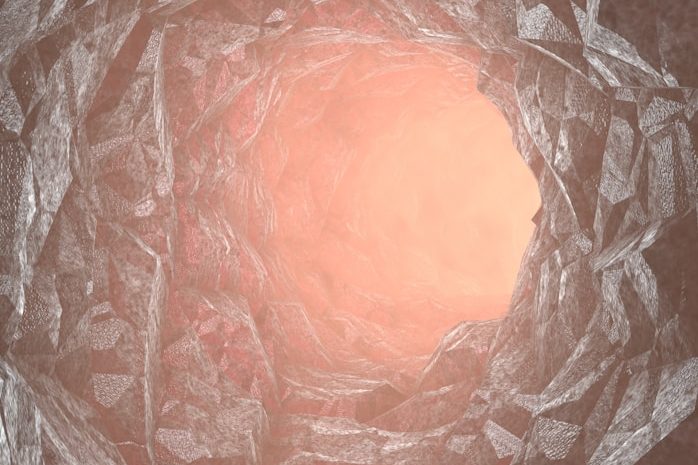 A abertura de um tubo com paredes curvas e luz suave emanando de dentro.