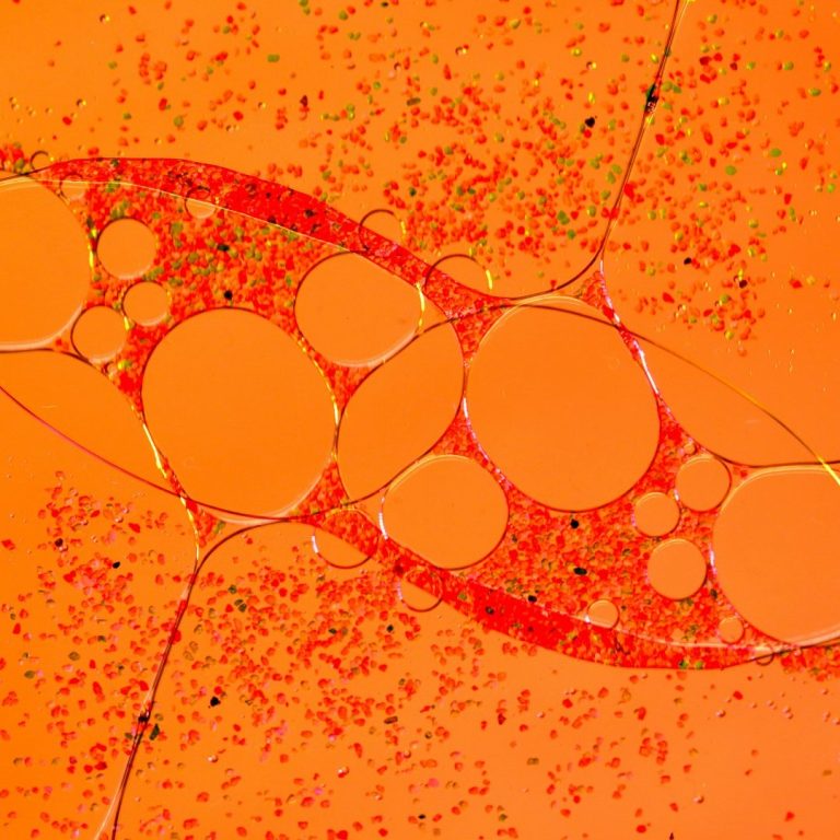 Estructura abstracta con formas redondas sobre un fondo naranja vibrante. Aumento íntimo masculino.