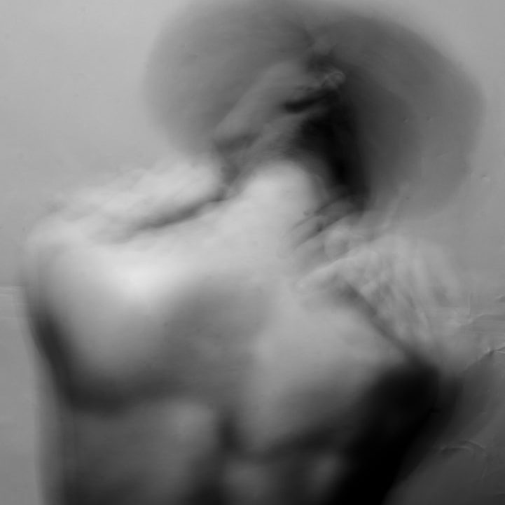 Figura humana en movimiento, con un fondo desenfocado en blanco y negro. Tratamiento Avanzado del Dolor.