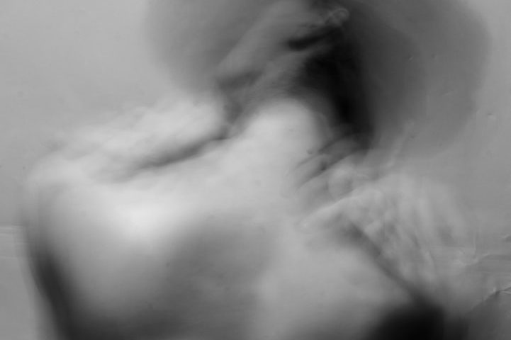 Silueta desenfocada de una persona en movimiento con sombrero.